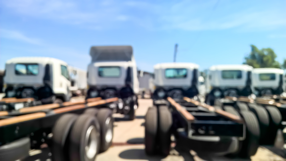 Commercial Vehicle Loans - Blurry scene of group of trailer truck parking on the yard for background